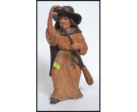 A vintage chalk ware fair ground prize modelled as a witch, with her broom stick. H49cm