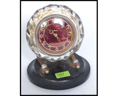 An unusual mid century retro Russian mantel clock. The red dial with cyrillic writing set within cut glass and over black bak
