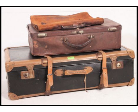 A vintage mid century leather strapped suitcase along with a leather example and vintage leather attache case