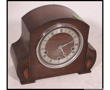 A 1940's oak cased mantel clock with silvered dial striking on a chime. H22 x W26 x D12cm 