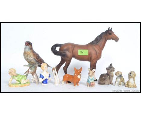 A collection of ceramic figurines to include a Royal Worcester  ' Michael ' by FG Doughty, Beswick Corgi, Royal Doulton cat, 