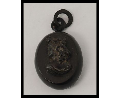 A Victorian Whitby jet locket carved in high relief with a bust portrait of a lady complete with loop attachment. The interio