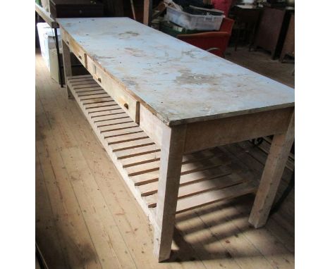 A large pine and formica topped table, fitted with two frieze drawers to a slatted shelf, 96ins x 30ins, height 32.5ins