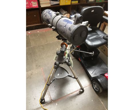 A Celestron AstroMaster 130 telescope with instructions manual and some accessories in a bag 