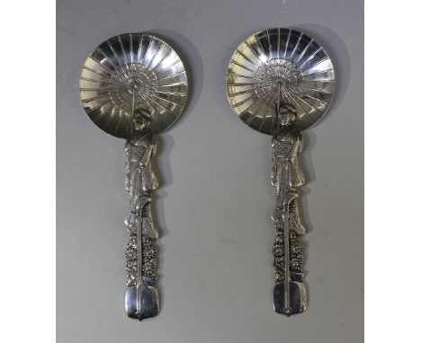 A pair of Japanese sterling silver decorative spoons, each in the form of a lady wearing Japanese costume carrying an open pa