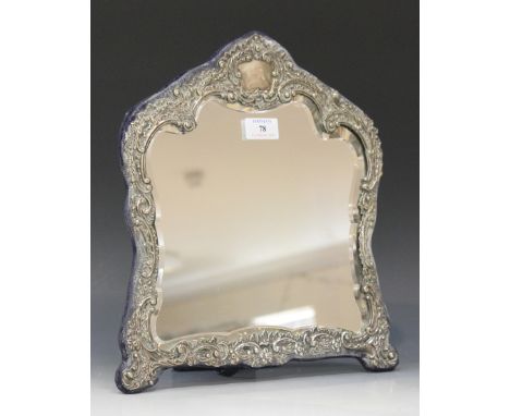 An Edwardian silver mounted dressing table mirror of shaped outline with embossed 'C' scroll and foliate surround, Birmingham