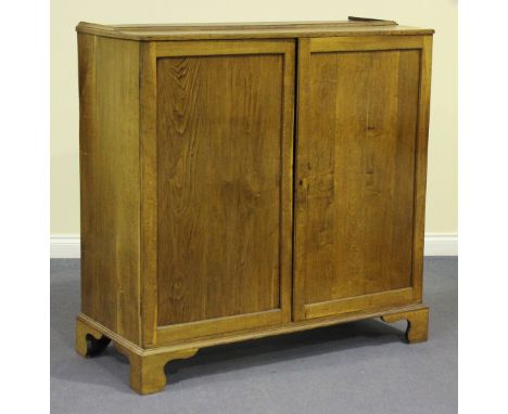 A 19th century oak side cabinet, fitted with a pair of panel doors enclosing adjustable shelves, on bracket feet, height 122c