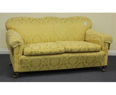 A 20th century two-seat sofa, upholstered in golden floral damask, raised on bun feet, height 88cm, length 180cm.