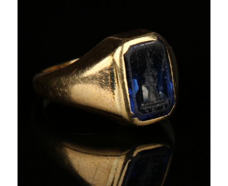 A gold and intaglio sapphire signet ring, the cut cornered rectangular cut sapphire engraved with a family crest, the shank d