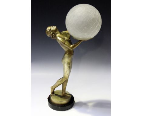 An Art Deco gilded cast spelter table lamp in the form of a nude maiden, the standing figure supporting a crackle glass globu
