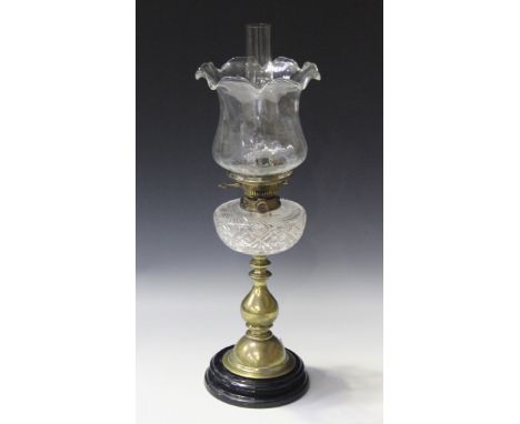 A late Victorian brass table oil lamp with a clear glass shade and a cut glass reservoir, the wick winder marked 'Hinks's No.