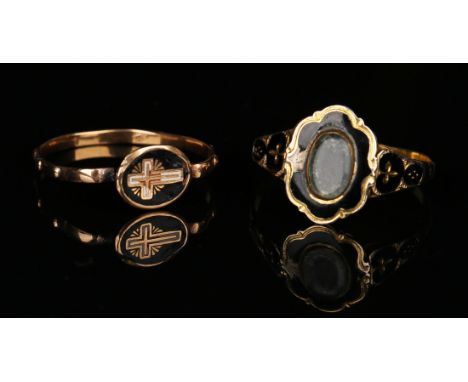 A Victorian gold and black enamelled mourning ring, glazed with an oval locket compartment within a cartouche shaped surround