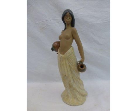A Lladro figure of a semi-clad native lady carrying a water pitcher.