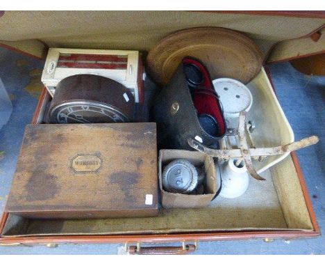 A suitcase with an assortment of collectables including a radio, mantle clock, scales, etc.