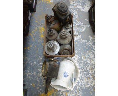An assortment of oil lamp reservoirs and bases, two coaching lanterns and a jug and bowl set.