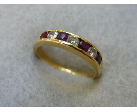 An 18ct gold diamond and ruby 1/4 set eternity ring comprising three diamonds and four rubies, size K.