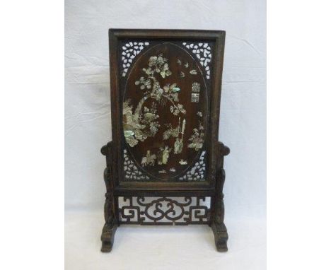 A Chinese wooden carved fretwork decorated table top screen, the panel inlaid with mother of pearl depicting figures, horse w