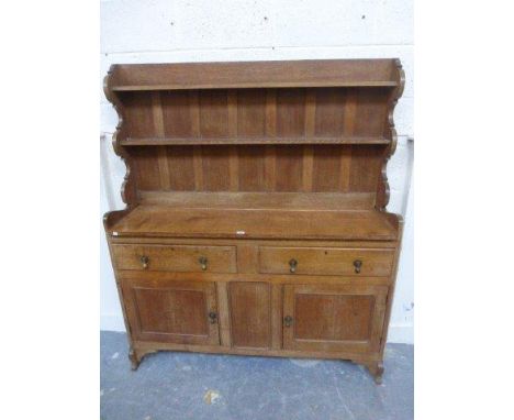 A Heals style light oak cottage dresser, the plate rack above two drawers and panelled cupboard doors. 