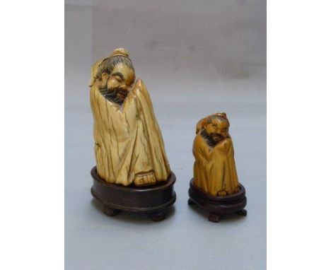 Two 19th Century Chinese mammoth ivory carved figures depicting Monko sleeping, wrapped in a cloak, one signed to the base, r