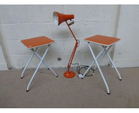 A pair of 1960s orange-topped folding stools and an orange angle-poise lamp.