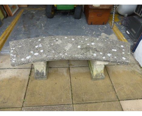 A curved reconstituted stone garden bench and a metal garden table.