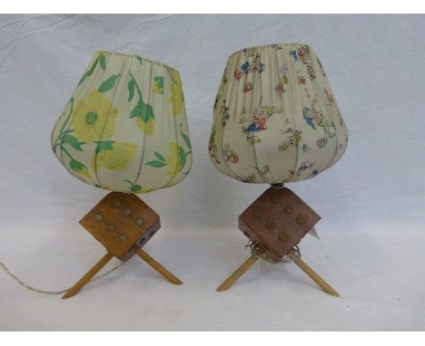 A pair of 1950s lamp bases in the form of dice with tripod supports.