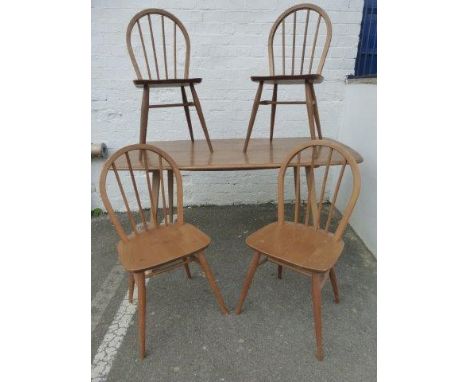 An Ercol light elm dining table and four chairs.