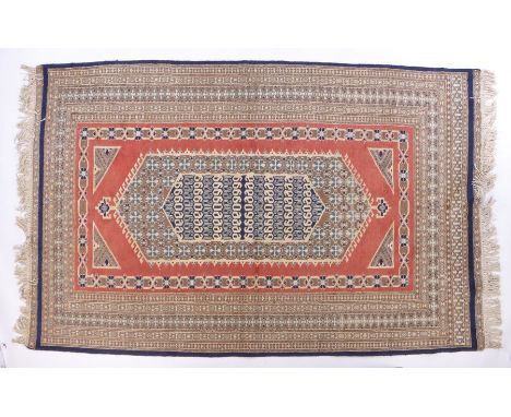 Middle Eastern carpet, the puce ground with scroll decorated lozenge centre surrounded by multiple borders and tasselled ends