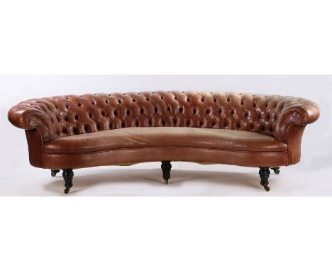 Unusual early 20th Century Chesterfield leather sofa, the arched sofa with button backs and stuff over seat raised on turned 