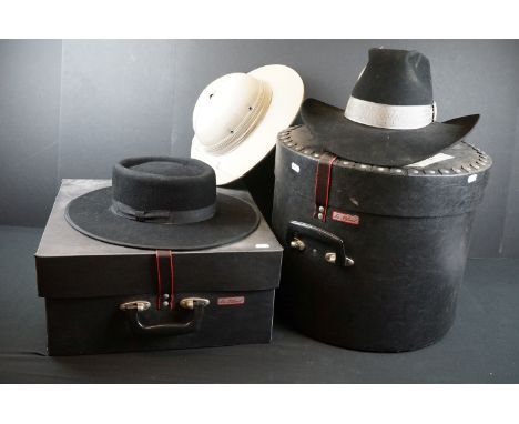 A collection of hats to include a pith helmet and a cowboy hat contained within two hat boxes. 