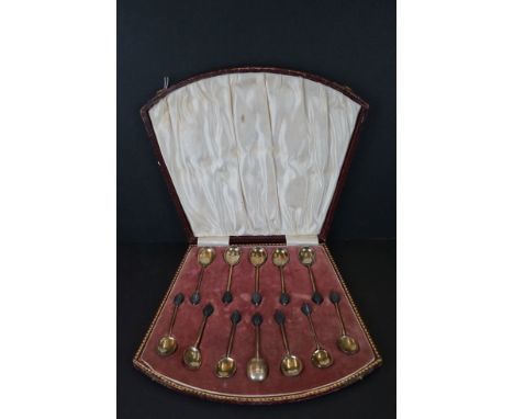 Cased set of Twelve Silver Bean Top Coffee Spoons by Hukin and Heath, Birmingham 1929, in an Art Deco fan shaped fitted case 