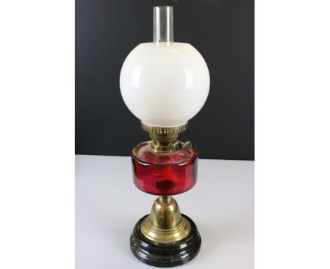 Victorian Brass Oil Lamp with Cranberry Glass Well, Opaque Bulbous Shade and Black Glazed Base, 58cm high 