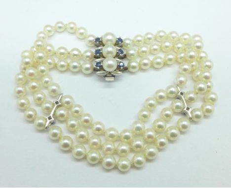 A three strand pearl bracelet set with sapphires and diamonds on an 18ct white gold clasp 