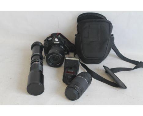 A CANON EOS 500D DIGITAL SLR CAMERA WITH A CANON EFS 18-135MM LENS, CANON EF 75-300MM ZOOM LENS AND A ROKINON F8 35-500MM TEL