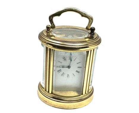 Small Vintage bowed glass brass carriage clock measures approx 11cm from top of handle complete with key the clock is ticking