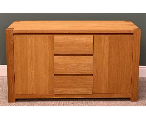 ULTRAMODERN LIGHT OAK SIDEBOARD, having three central opening drawers flanked by twin cupboard doors on substantial block cor