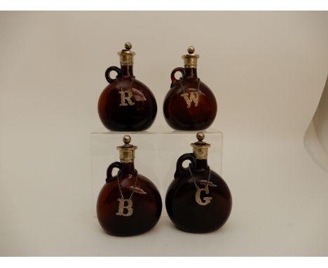 A SET OF FOUR BROWN GLASS LIQUOR DECANTERS each with EP mounts and labels including G, W, R &amp; B, 20 cm high (4) Condition