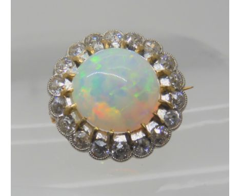 AN OPAL AND DIAMOND BROOCH opal approx 10.4mm in diameter, surrounded with a row of diamonds which are estimated approx 0.50c