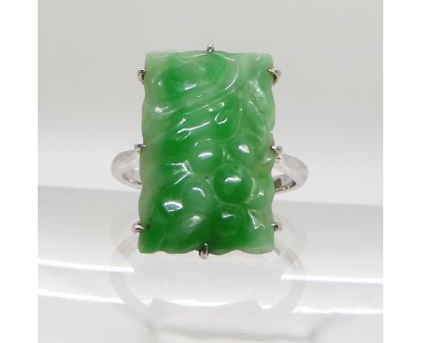 A 9CT WHITE GOLD CHINESE GREEN HARDSTONE RING the hardstone carved with fruit, dimensions 1.8cm x 1.2cm, finger size N, weigh