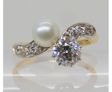 AN 18CT DIAMOND AND PEARL RING the main diamond is estimated at 0.75cts with old cut diamonds to both shoulders, diameter of 