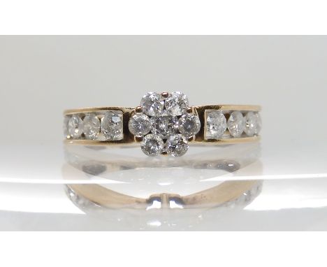 A 9CT GOLD DIAMOND FLOWER RING set with estimated approx 0.80cts of brilliant cut diamonds. Finger size M1/2, weight 2.7gms C