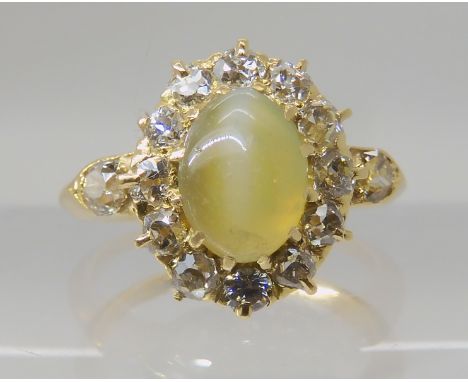 A CHRYSOBERYL AND OLD CUT DIAMOND CLUSTER RING the central chrysoberyl is approx 7.8mm x 5.8mm x 3.9mm, surrounded with a hal