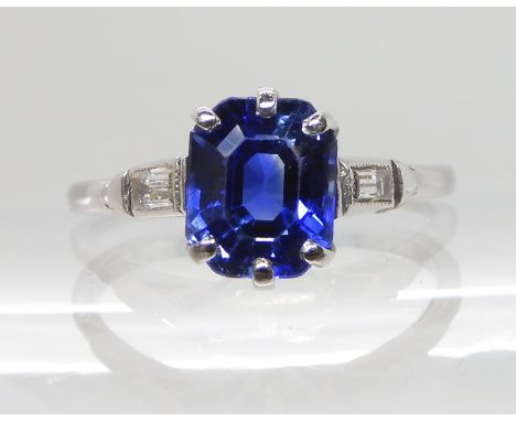 AN 18CT AND PLATINUM SAPPHIRE AND DIAMOND RING of classic Art Deco design with baguette cut diamonds to the shoulders, sapphi