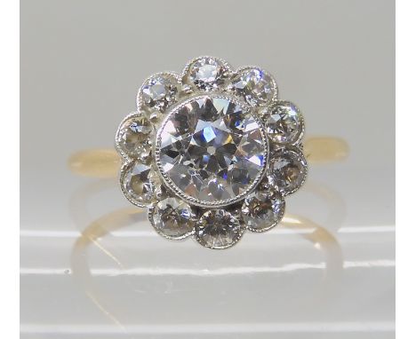 AN OLD CUT DIAMOND SET FLOWER RING the central old cut diamond is estimated approx 1.10cts and surrounded with 0.62cts of old