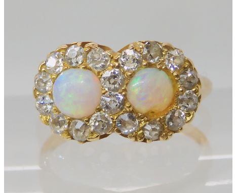 A BRIGHT YELLOW METAL OPAL AND DIAMOND RING the two opals of approx 4mm, are surrounded with old cut diamonds to an estimated