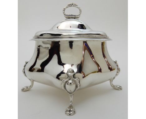 A SILVER TEA CADDY unclear maker's marks, Chester 1906, of four sided bombe shape with hinged cover on four on four outswept 