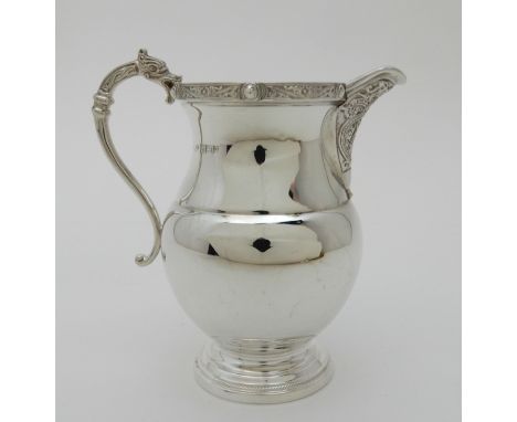 A SILVER CREAM JUG by Adie Brothers Limited, Birmingham 1964, of baluster form with a Celtic decorated, banded rim and spout,