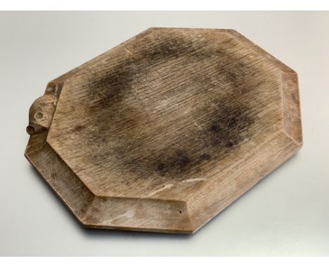 Workshop of Robert (Mouseman) Thompson, a shaped octagonal oak cheese or bread board, with carved mouse signature. 25cm by 30