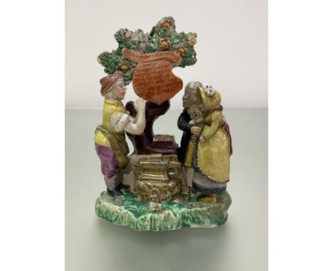 A Staffordshire pearlware Gretna Green figure group, c. 1820, the couple standing before a blacksmith beneath a tree suspendi