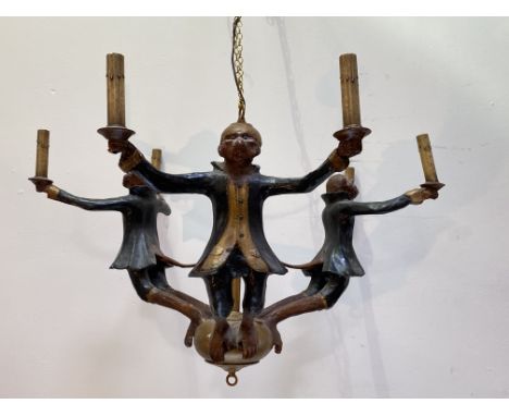 A painted and carved wooden six-light chandelier, the central giltwood sphere issuing three arms modelled and painted as monk